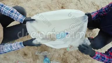 志愿者把塑料垃圾放进袋子里。 清洁海滩，<strong>爱护环境</strong>.. 顶部视图